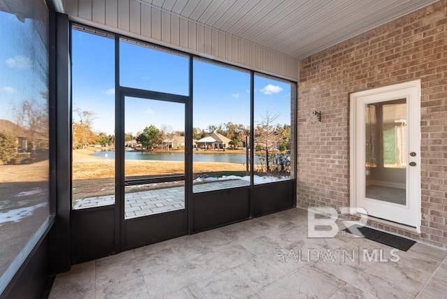 unfurnished sunroom featuring a water view and wooden ceiling