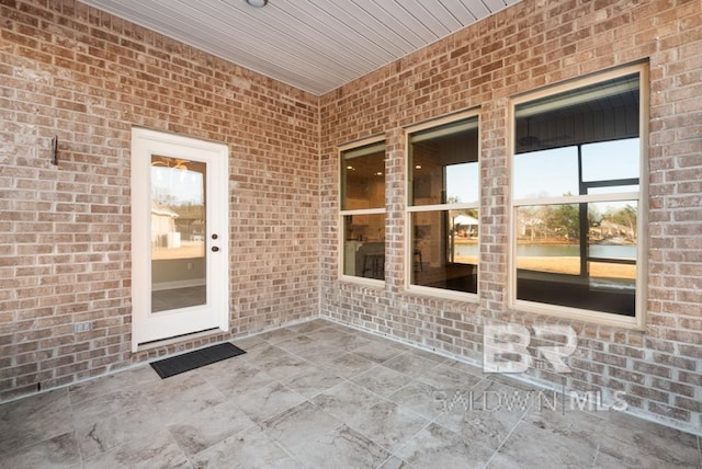 doorway to property with a patio and brick siding