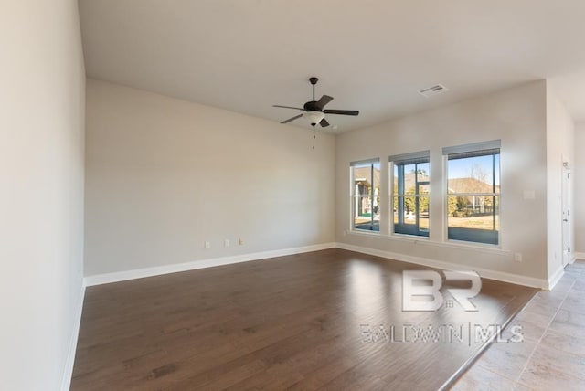 unfurnished room featuring ceiling fan, light wood finished floors, visible vents, and baseboards