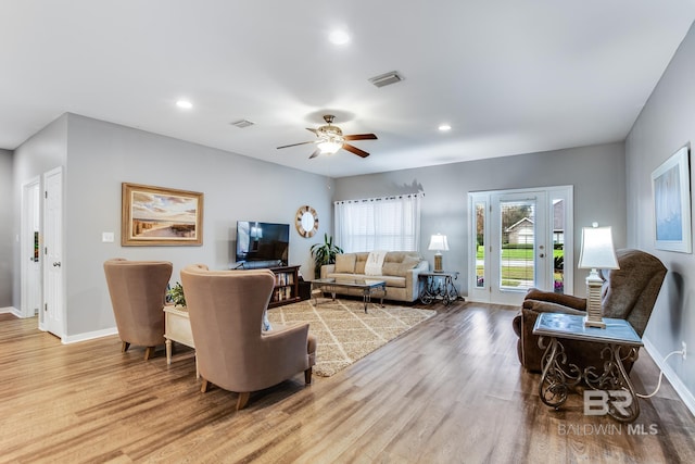 living room with ceiling fan and light hardwood / wood-style floors