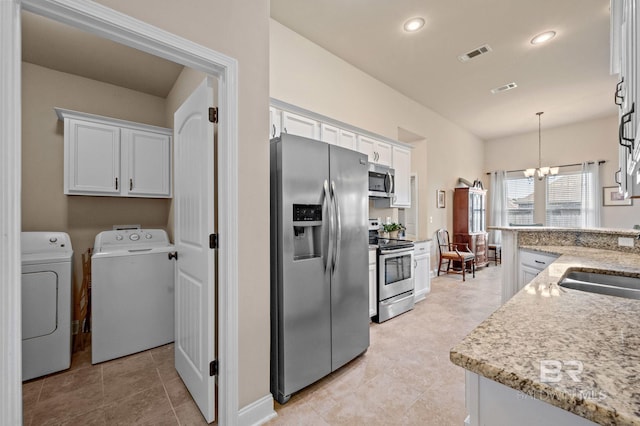 14766 Sonoma Blvd, Silverhill, AL 36576 - kitchen with a chandelier, white cabinetry, washing machine and clothes dryer, appliances with stainless steel finishes, and visible vents