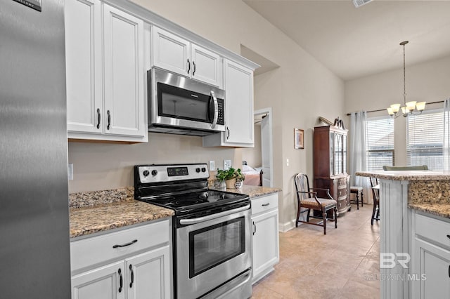 14766 Sonoma Blvd, Silverhill, AL 36576 - kitchen with appliances with stainless steel finishes, white cabinetry, light stone counters, hanging light fixtures, and a notable chandelier
