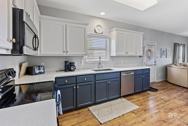 kitchen with sink, blue cabinetry, dishwasher, electric range, and white cabinets