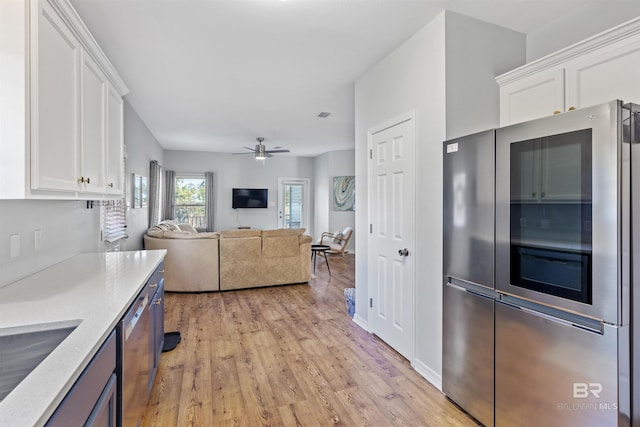 kitchen featuring sink, light hardwood / wood-style flooring, appliances with stainless steel finishes, ceiling fan, and white cabinets