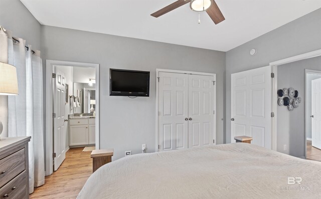 bedroom featuring connected bathroom, light hardwood / wood-style floors, a closet, and ceiling fan