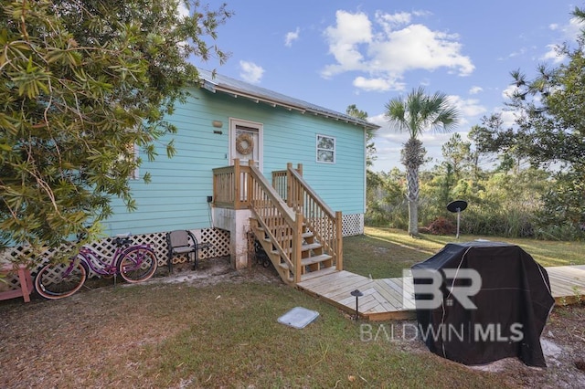 rear view of property featuring a lawn