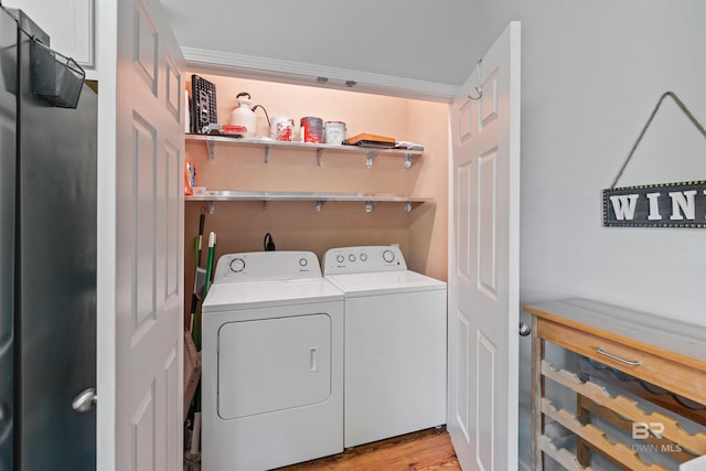 laundry room with washer and clothes dryer and light wood-type flooring