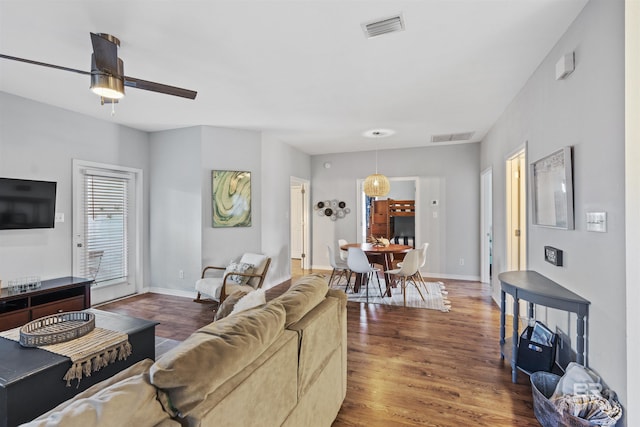 living room featuring ceiling fan and dark hardwood / wood-style flooring