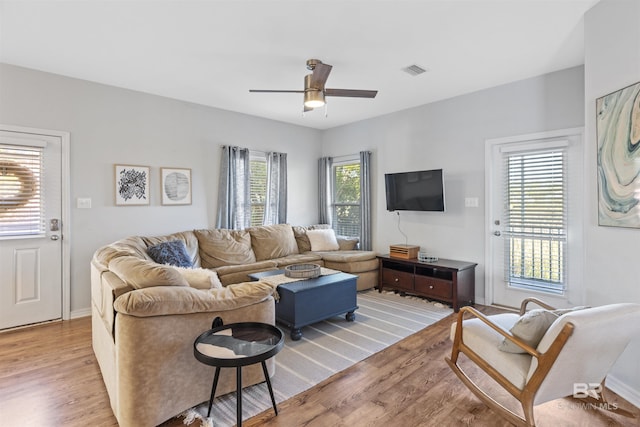 living room with ceiling fan, a healthy amount of sunlight, and light wood-type flooring