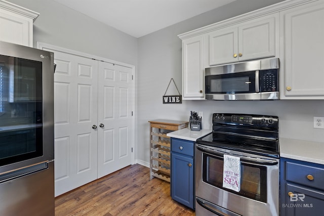 kitchen with blue cabinetry, white cabinetry, and stainless steel appliances