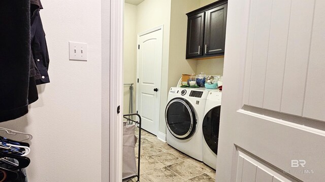 clothes washing area with cabinets and independent washer and dryer