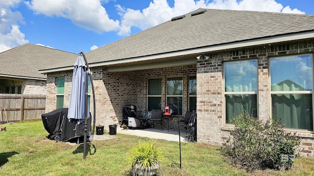 rear view of property with a lawn and a patio area