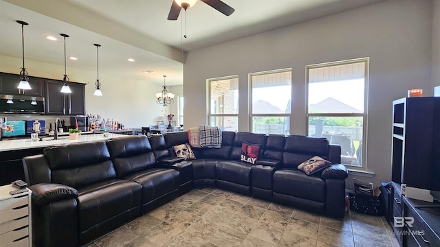 living room featuring ceiling fan with notable chandelier and sink