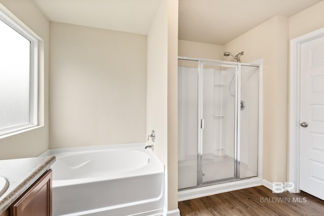 bathroom featuring hardwood / wood-style flooring, vanity, plenty of natural light, and shower with separate bathtub