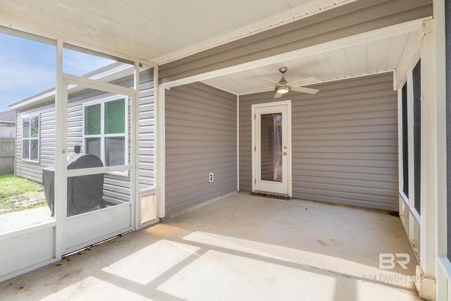 unfurnished sunroom featuring ceiling fan