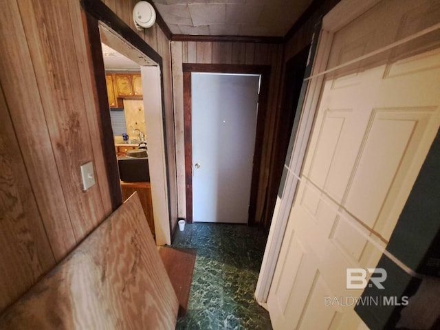 hallway featuring wooden walls