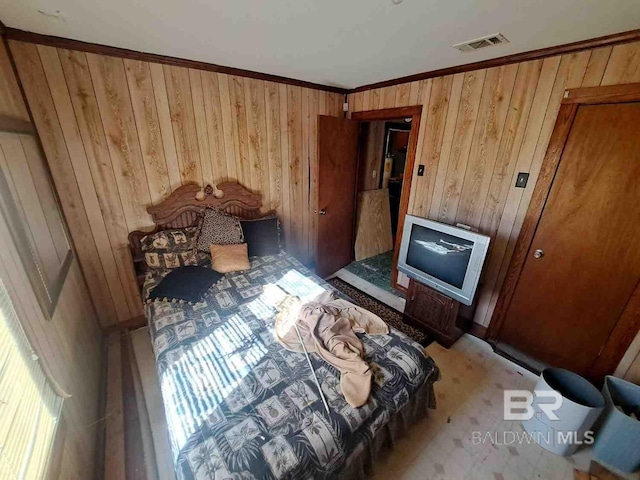 bedroom featuring wood walls, ornamental molding, and a fireplace