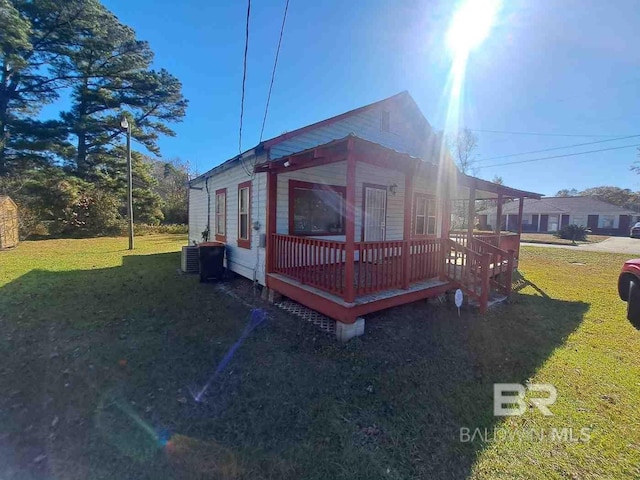 view of side of property with a lawn, cooling unit, and a deck