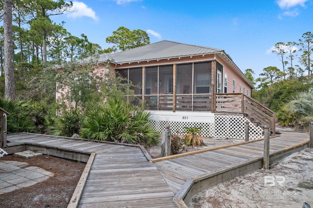 exterior space with a wooden deck and a sunroom