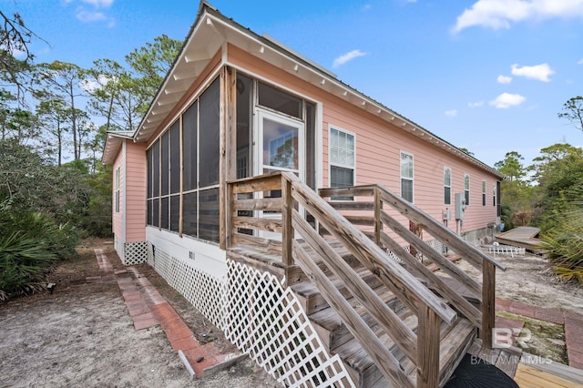 rear view of property featuring a sunroom