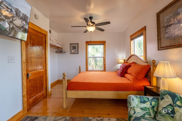 bedroom featuring light wood-style flooring, multiple windows, baseboards, and visible vents