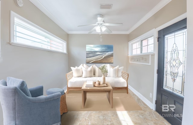 living area with ceiling fan, visible vents, baseboards, and crown molding