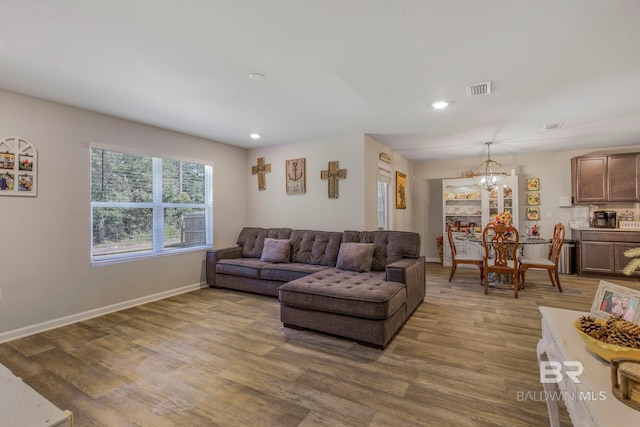 living room featuring hardwood / wood-style flooring and an inviting chandelier