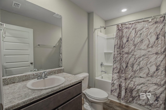 full bathroom featuring hardwood / wood-style floors, toilet, shower / bath combo, and vanity