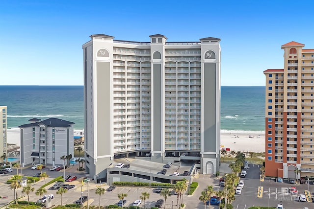 view of building exterior featuring a water view and a view of the beach