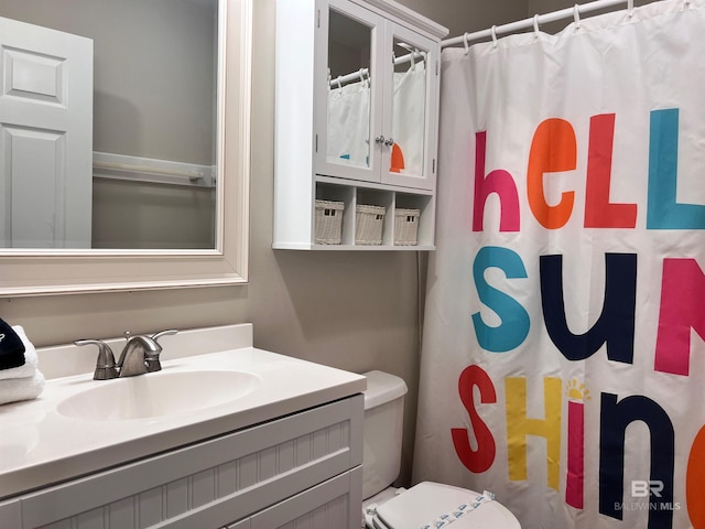 bathroom with curtained shower, toilet, and vanity