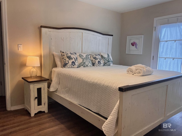 bedroom with dark hardwood / wood-style floors