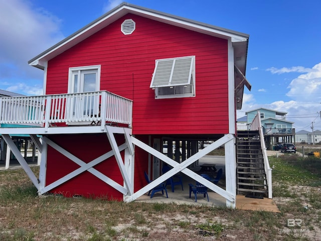 403 E Bernard Ct, Gulf Shores, AL 36542 - view of home's exterior featuring stairs, a deck, and a patio