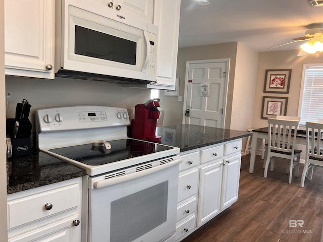 kitchen with dark stone countertops, white cabinetry, white appliances, ceiling fan, and dark hardwood / wood-style floors