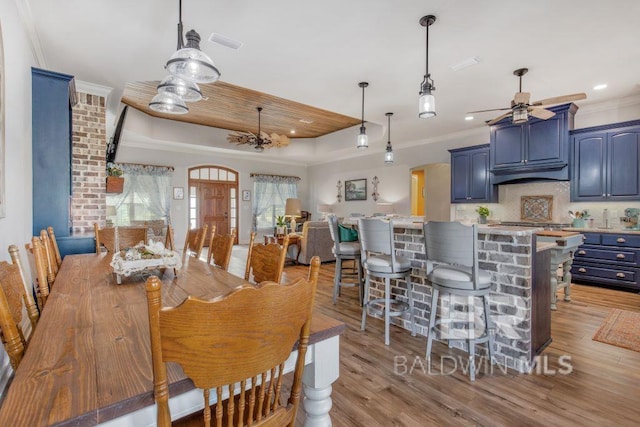 dining area with light hardwood / wood-style flooring, ceiling fan, and crown molding