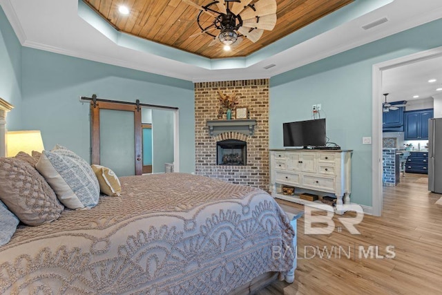 bedroom with stainless steel fridge, a fireplace, light wood-type flooring, a tray ceiling, and wooden ceiling