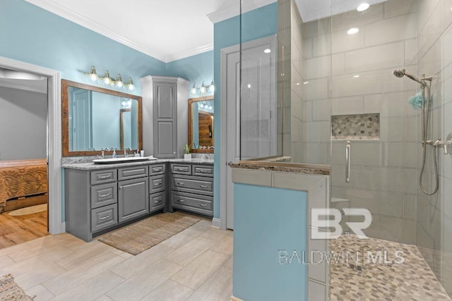 bathroom featuring vanity, hardwood / wood-style floors, crown molding, and a shower with shower door