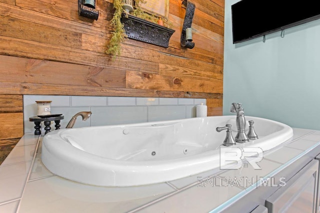 bathroom featuring wood walls and a tub to relax in