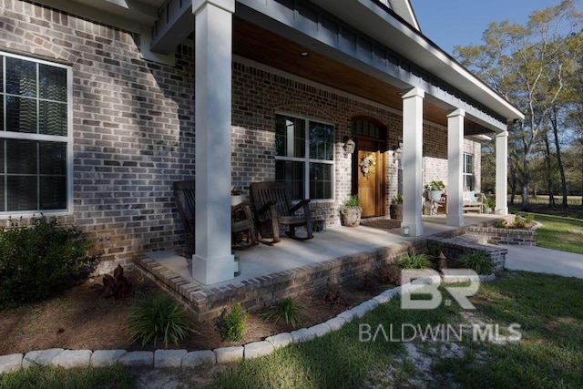 view of exterior entry featuring covered porch