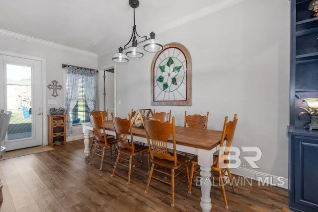 dining space with ornamental molding, an inviting chandelier, and dark hardwood / wood-style floors