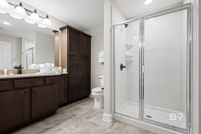 bathroom with vanity, toilet, and an enclosed shower