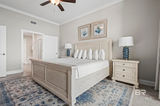 tiled bedroom with connected bathroom, ceiling fan, and ornamental molding