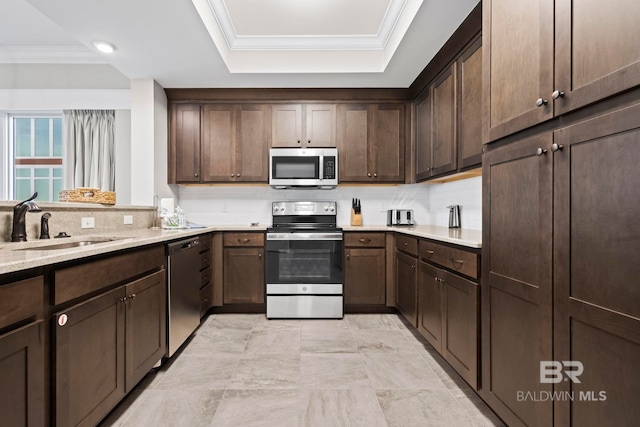 kitchen featuring dark brown cabinetry, light stone countertops, and appliances with stainless steel finishes