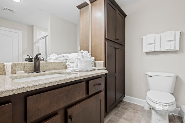 bathroom with vanity, toilet, and walk in shower