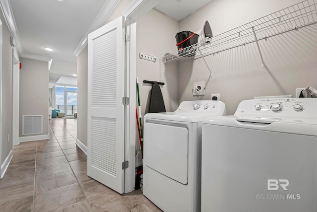 laundry area with independent washer and dryer, light tile patterned floors, and ornamental molding