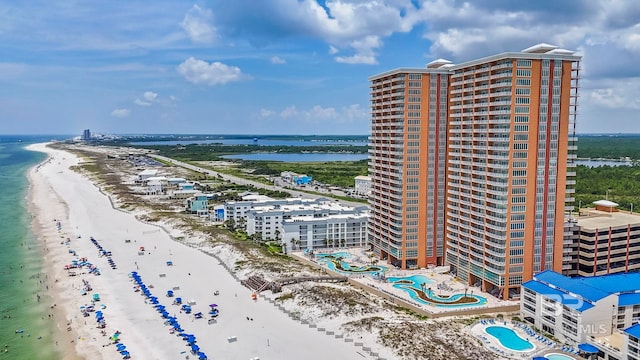 drone / aerial view featuring a beach view and a water view