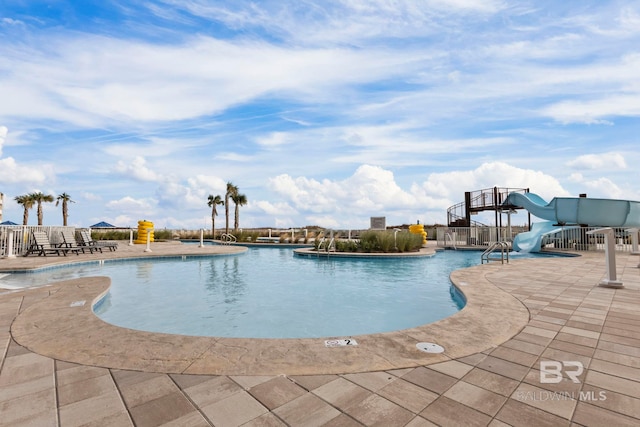 view of swimming pool featuring a water slide and a patio