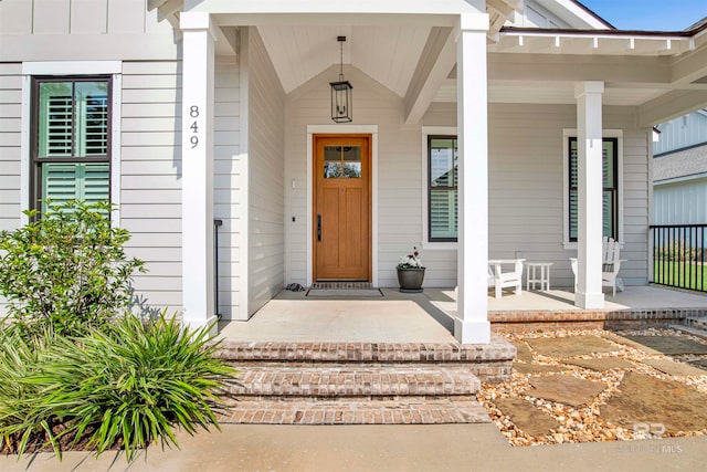 view of exterior entry featuring covered porch