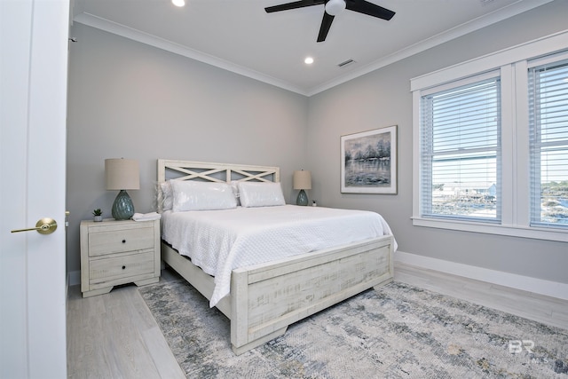 bedroom featuring crown molding, ceiling fan, wood-type flooring, and multiple windows