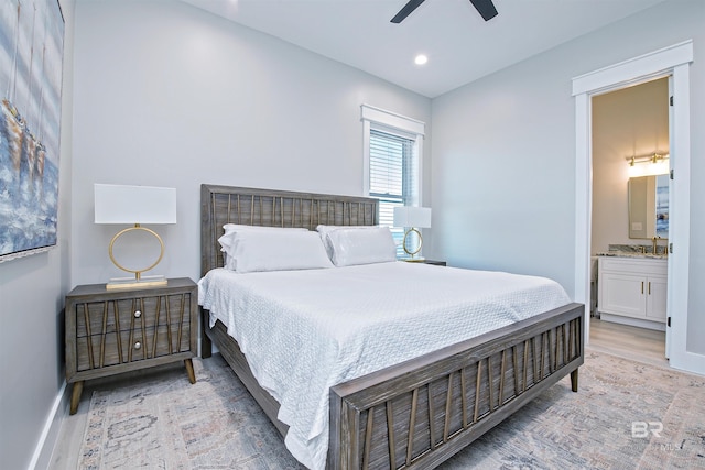 bedroom featuring light hardwood / wood-style floors, ceiling fan, and ensuite bathroom