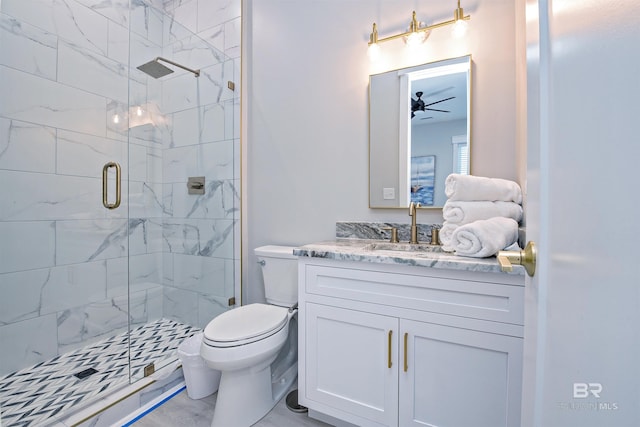 bathroom featuring an enclosed shower, vanity, toilet, and ceiling fan